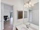 A well-lit bathroom features a modern vanity, a large mirror, and a glimpse into the home's interior at 10061 Cozy Grove Dr, Venice, FL 34293