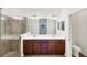 Bathroom with a double vanity, a walk-in shower, and an open doorway leading to another room at 10061 Cozy Grove Dr, Venice, FL 34293
