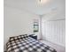 Bright bedroom featuring carpet, white walls, and a checkered blanket on the bed at 10061 Cozy Grove Dr, Venice, FL 34293