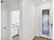 Bright entryway with decorative glass front door and access to the laundry room with a sink and white cabinets at 10061 Cozy Grove Dr, Venice, FL 34293