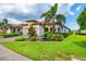 Beautiful single-story home showcasing lush landscaping, a paver driveway, and a well-maintained lawn at 10061 Cozy Grove Dr, Venice, FL 34293