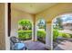 Charming front porch with seating area, decorative columns, and views of the neighborhood at 10061 Cozy Grove Dr, Venice, FL 34293