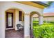 Welcoming front porch with brick pavers, comfortable seating, and decorative columns at 10061 Cozy Grove Dr, Venice, FL 34293