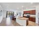 Open-concept kitchen with granite countertops, dark wood cabinets, and a view of the backyard at 10061 Cozy Grove Dr, Venice, FL 34293