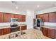 Well-lit kitchen boasts stainless appliances, granite counters, and rich wood cabinetry at 10061 Cozy Grove Dr, Venice, FL 34293