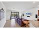 Bright open-concept living room with tile flooring, modern furniture, and sliding glass doors to backyard at 10061 Cozy Grove Dr, Venice, FL 34293