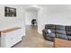 Open-concept living room featuring tile floors, a cozy sofa, and a cabinet at 10061 Cozy Grove Dr, Venice, FL 34293