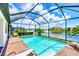 Beautiful screened-in pool with brick patio and peaceful lake view under a bright sky at 10061 Cozy Grove Dr, Venice, FL 34293