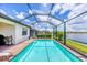 Refreshing screened-in pool with a brick deck and scenic lake views from the backyard at 10061 Cozy Grove Dr, Venice, FL 34293