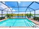 Sparkling screened-in pool offers stunning lake views and brick-paved patio at 10061 Cozy Grove Dr, Venice, FL 34293