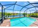Enclosed pool area featuring a clear pool, patio, and tranquil lake views in backyard at 10061 Cozy Grove Dr, Venice, FL 34293