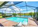Inviting screened-in pool area with clear blue water and picturesque lake views at 10061 Cozy Grove Dr, Venice, FL 34293