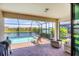 Covered patio view showcasing a sparkling screened-in pool and a tranquil lake at 10061 Cozy Grove Dr, Venice, FL 34293