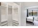 Walk-in closet featuring custom shelves and drawers adjacent to a bedroom and a view of the lake at 10061 Cozy Grove Dr, Venice, FL 34293