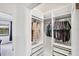 Walk-in closet with custom shelving and drawers, offering ample storage space, and a view to the water at 10061 Cozy Grove Dr, Venice, FL 34293
