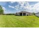 Expansive backyard featuring a large lawn and screened in patio area, great for outdoor relaxation and entertaining at 11240 Spring Gate Trl, Bradenton, FL 34211