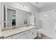 Bathroom featuring double sinks, white cabinets, a bathtub, and neutral colors at 11240 Spring Gate Trl, Bradenton, FL 34211