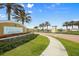 Inviting community entrance featuring lush landscaping, palm trees, and a decorative welcome sign for a welcoming atmosphere at 11240 Spring Gate Trl, Bradenton, FL 34211