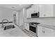 Contemporary kitchen featuring sleek appliances, ample counter space, and stylish white cabinetry at 11240 Spring Gate Trl, Bradenton, FL 34211