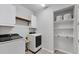 Laundry room featuring a washer, dryer, and built-in shelving at 11240 Spring Gate Trl, Bradenton, FL 34211