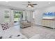 Bright living room with neutral tones, a ceiling fan, and a sliding glass door to the outdoors at 11240 Spring Gate Trl, Bradenton, FL 34211