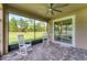 Covered screened patio with brick floors, white rocking chairs, a ceiling fan, and view to the yard at 11240 Spring Gate Trl, Bradenton, FL 34211