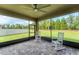 Covered screened patio with brick floors, white rocking chairs, and a ceiling fan at 11240 Spring Gate Trl, Bradenton, FL 34211