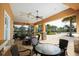 Covered patio featuring comfortable seating arrangements, providing a relaxing outdoor gathering space with palm trees and landscaping at 11240 Spring Gate Trl, Bradenton, FL 34211