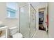 Bright bathroom featuring a glass walk-in shower, tiled floors, and a window offering natural light at 11560 Tapestry Ln, Venice, FL 34293
