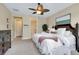 Cozy bedroom featuring plush carpet, ceiling fan, and views into the ensuite bathroom and spacious closet at 11560 Tapestry Ln, Venice, FL 34293
