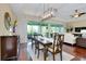 Dining room with views of the screened in lanai is adjacent to the living room and features wood floors at 11560 Tapestry Ln, Venice, FL 34293