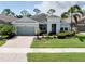 Charming single-story home with a well-manicured lawn, beautiful landscaping, and a two-car garage at 11560 Tapestry Ln, Venice, FL 34293
