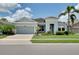 Inviting single-story home featuring lush landscaping, paver driveway, and charming curb appeal at 11560 Tapestry Ln, Venice, FL 34293
