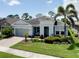 Charming single-story home with beautiful landscaping and a welcoming front porch swing at 11560 Tapestry Ln, Venice, FL 34293