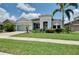 Delightful single-story home featuring verdant lawn, mature landscaping, and covered entry at 11560 Tapestry Ln, Venice, FL 34293