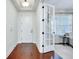 Hallway with gleaming hardwood floors, white trim, and entry door views to living room at 11560 Tapestry Ln, Venice, FL 34293