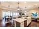 Spacious kitchen open to the dining room with a center island and modern pendant lighting at 11560 Tapestry Ln, Venice, FL 34293