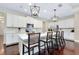 Bright kitchen features white cabinets, subway tile backsplash, hardwood floors, and a large center island with seating at 11560 Tapestry Ln, Venice, FL 34293