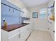 Bright laundry room featuring tile floors, washer and dryer, and built-in sink with wood countertop at 11560 Tapestry Ln, Venice, FL 34293