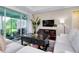 Living room with comfortable sofas, coffee table, area rug and view of the screened in lanai at 11560 Tapestry Ln, Venice, FL 34293