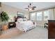 Calm main bedroom with plush carpet, ceiling fan, and bright windows is the perfect retreat at 11560 Tapestry Ln, Venice, FL 34293