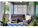 Cozy screened patio with a hot tub, wicker chair, blue rug, and tropical potted plants at 11560 Tapestry Ln, Venice, FL 34293