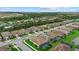 Beautiful aerial view of a well-maintained neighborhood with lush landscaping and a serene pond in the background at 11970 Lovegrass St, Venice, FL 34293