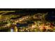 Night aerial view showcases the neighborhood's well-lit streets and vibrant buildings at 11970 Lovegrass St, Venice, FL 34293