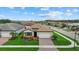 Aerial view of a single-Gathering home with a manicured lawn and paver driveway at 11970 Lovegrass St, Venice, FL 34293