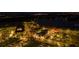 Night aerial view of lit up buildings, streets, and beautiful lake highlighting the area's appeal at 11970 Lovegrass St, Venice, FL 34293