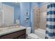 Blue-themed bathroom featuring modern fixtures and a shower-tub combination at 11970 Lovegrass St, Venice, FL 34293