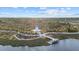 Scenic view of the community park featuring a unique white lighthouse structure, dock, walking paths and beautiful lake at 11970 Lovegrass St, Venice, FL 34293