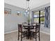 Dining area with a round wooden table, gray walls, and decorative window accents at 11970 Lovegrass St, Venice, FL 34293