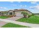 Attractive single-story home with a tile roof, green lawn, and attached two-car garage at 11970 Lovegrass St, Venice, FL 34293